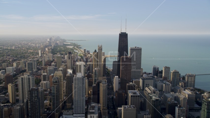 John Hancock Center surrounded by smaller skyscrapers in Downtown Chicago, Illinois Aerial Stock Photo AX0001_035.0000400F | Axiom Images