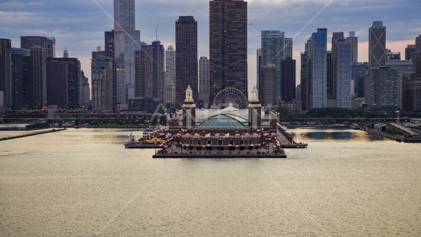 Navy Pier with Downtown Chicago skyscrapers behind it on a cloudy day at sunset, Illinois Aerial Stock Photo AX0003_066.0000089F | Axiom Images