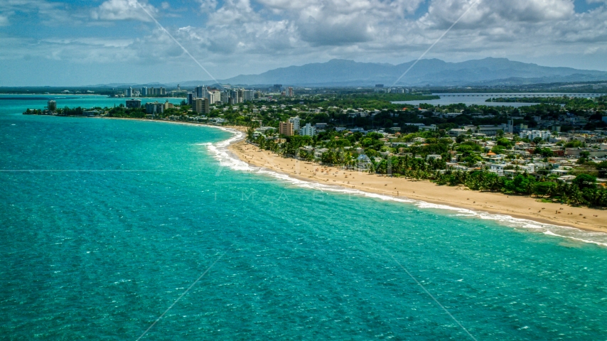 Beachfront homes beside beaches with tourists and crystal blue water, San Juan, Puerto Rico  Aerial Stock Photo AX102_005.0000000F | Axiom Images