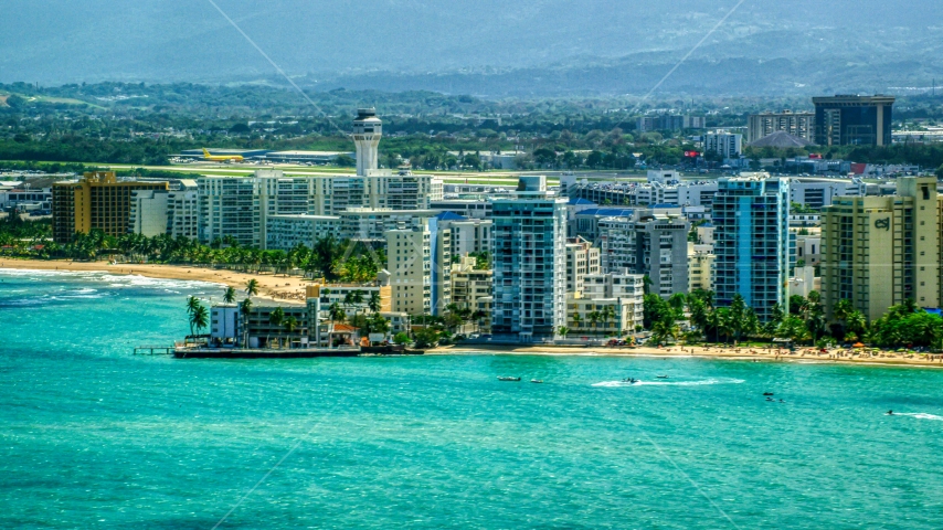 Waterfront apartment buildings beside crystal blue waters, Carolina, Puerto Rico  Aerial Stock Photo AX102_008.0000000F | Axiom Images