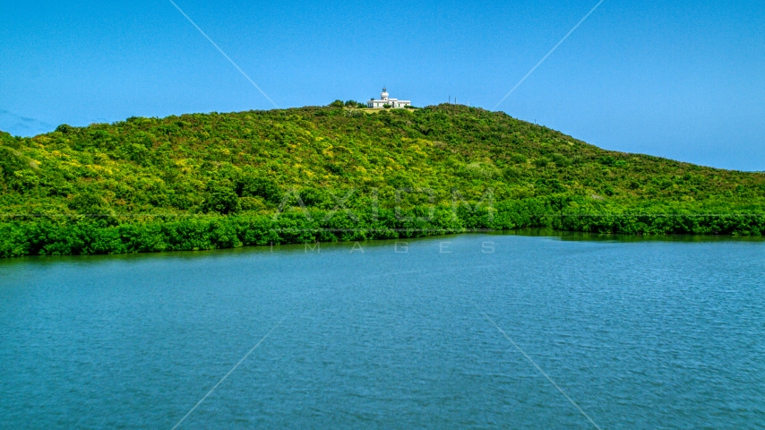 Cape San Juan Light on a hilltop in Fajardo, Puerto Rico  Aerial Stock Photo AX102_061.0000230F | Axiom Images