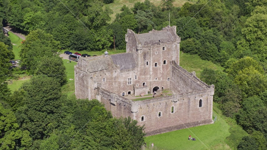 Historic Doune Castle with tourists on the grounds, Scotland Aerial Stock Photo AX109_071.0000116F | Axiom Images