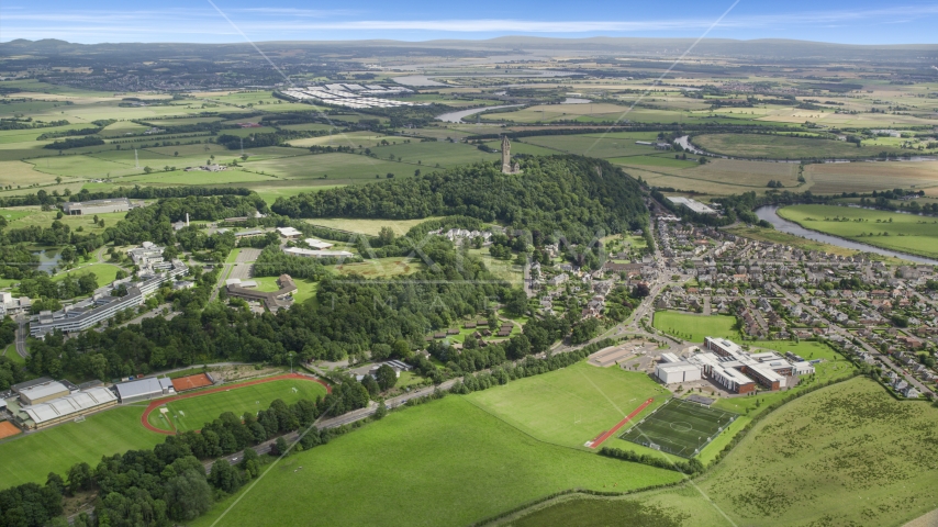 The Wallace Monument on a hill near a residential area, Stirling, Scotland Aerial Stock Photo AX109_097.0000160F | Axiom Images