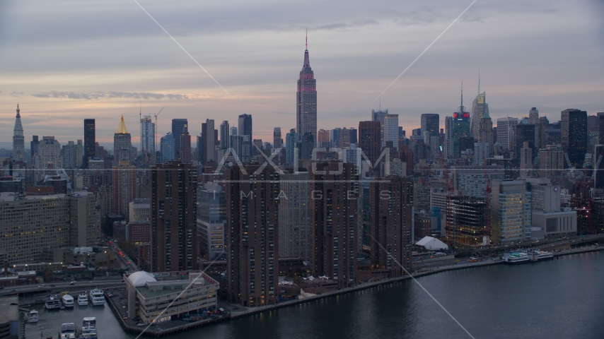 Empire State Building seen from riverfront apartment buildings at sunset in New York City Aerial Stock Photo AX121_049.0000000F | Axiom Images