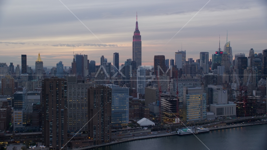 Empire State Building seen from riverfront office and apartment buildings at sunset in New York City Aerial Stock Photo AX121_049.0000187F | Axiom Images