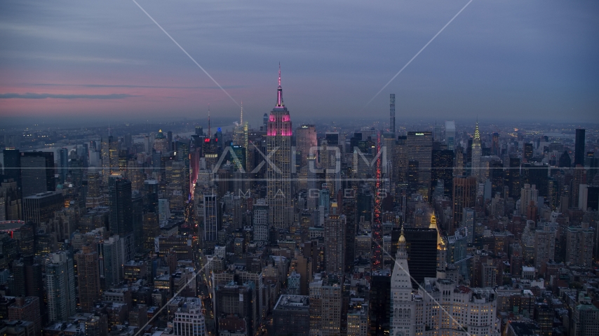 Empire State Building with pink lights and Midtown high-rises at Sunset in New York City Aerial Stock Photo AX121_081.0000239F | Axiom Images