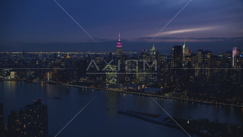 UN Building and Midtown seen from East River at night in New York City Aerial Stock Photo AX121_142.0000107F | Axiom Images