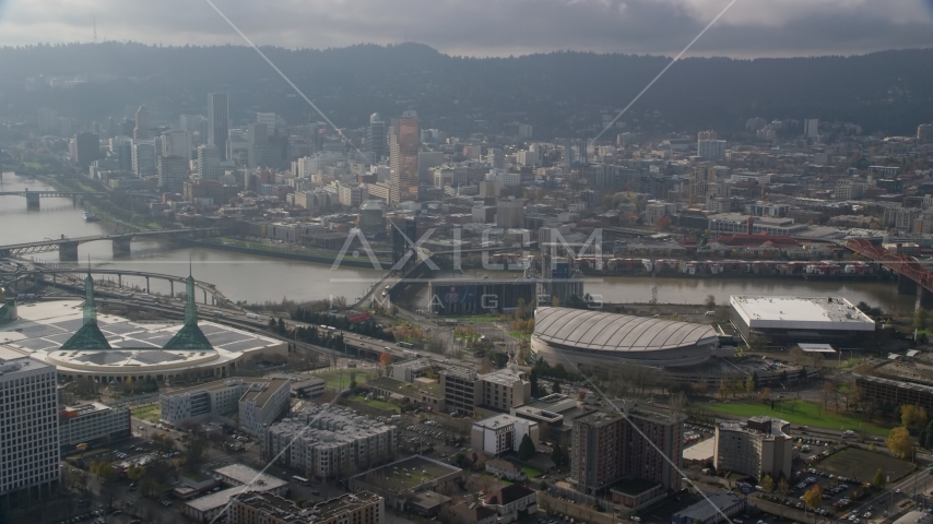 A view of Downtown Portland skyscrapers across the Willamette River from Moda Center in Oregon Aerial Stock Photo AX153_112.0000311F | Axiom Images