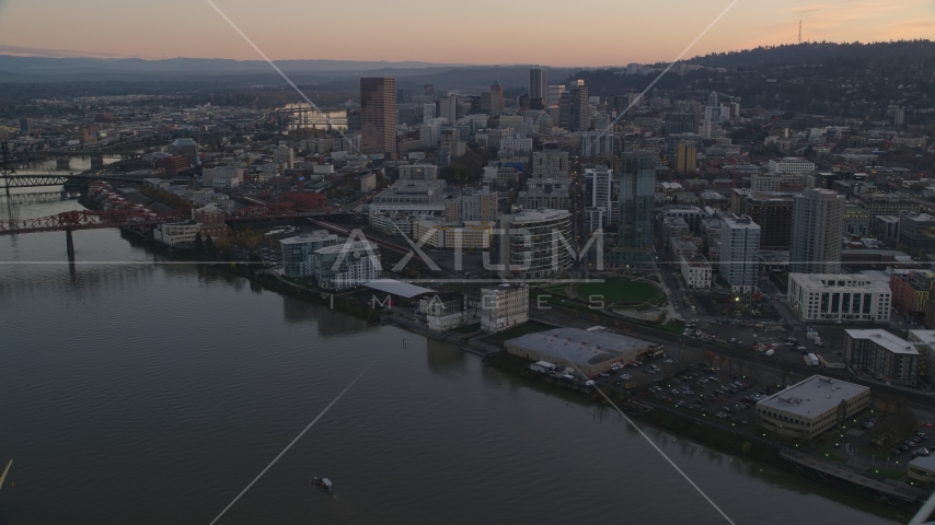 Skyscrapers and buildings along the river at sunset, Downtown Portland, Oregon Aerial Stock Photo AX155_183.0000300F | Axiom Images