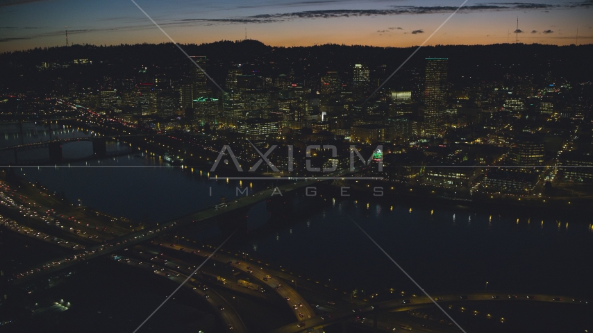 A view across the Willamette River of Downtown Portland and the White Stag Sign, Oregon, at night Aerial Stock Photo AX155_316.0000329F | Axiom Images