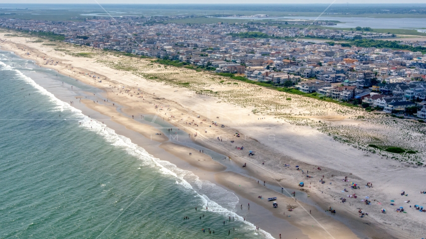 People on the beach and beachfront homes in Ocean City, New Jersey Aerial Stock Photo AXP071_000_0024F | Axiom Images