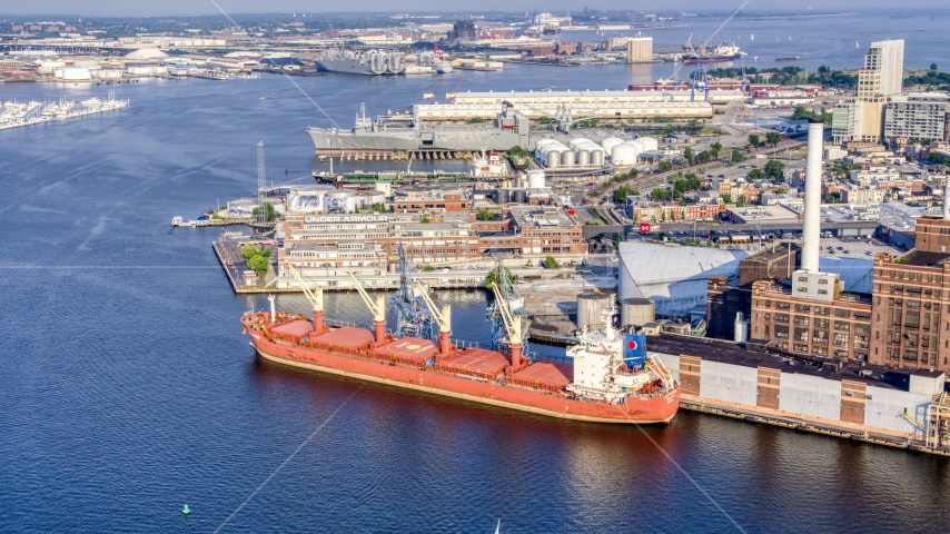 A cargo ship at Domino Sugar Factory, and waterfront factory buildings, Baltimore, Maryland Aerial Stock Photo AXP073_000_0014F | Axiom Images