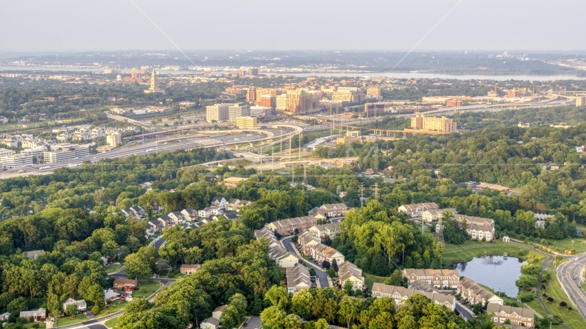 A residential neighborhood, row houses, with office buildings and monument in the distance, Alexandria, Virginia, sunset Aerial Stock Photo AXP076_000_0001F | Axiom Images