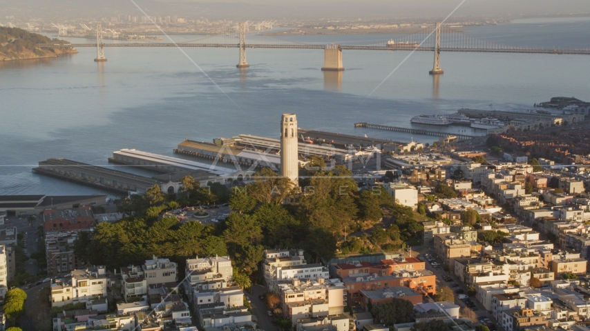 Coit Tower with Bay Bridge in background, North Beach, San Francisco, California, sunset Aerial Stock Photo DCSF07_008.0000069 | Axiom Images