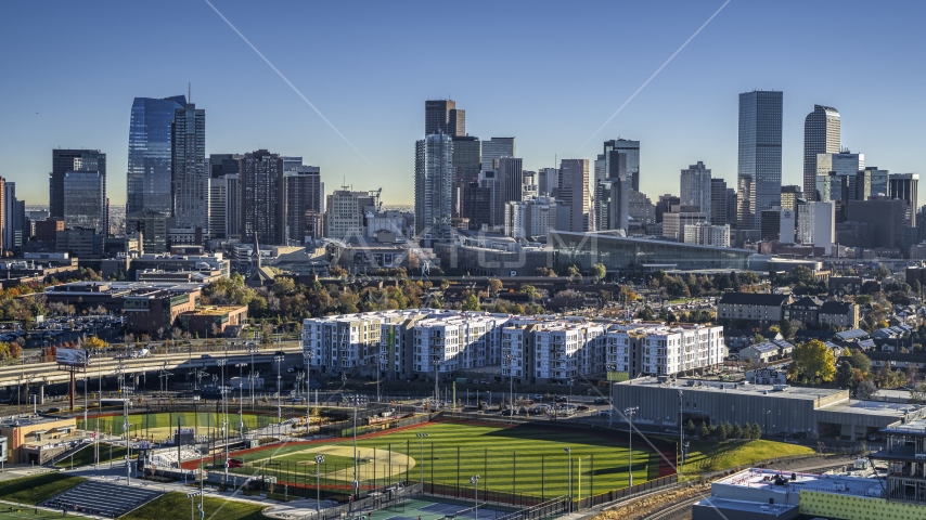 Towering skyscrapers of city skyline seen from baseball field by apartment building, Downtown Denver, Colorado Aerial Stock Photo DXP001_000124 | Axiom Images