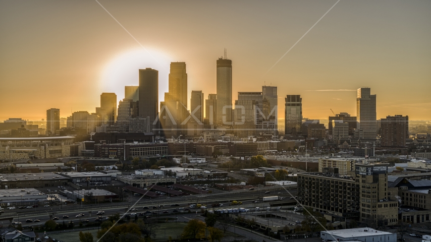 The rising sun glowing behind towering skyscrapers in the city's skyline in Downtown Minneapolis, Minnesota Aerial Stock Photo DXP001_000265 | Axiom Images