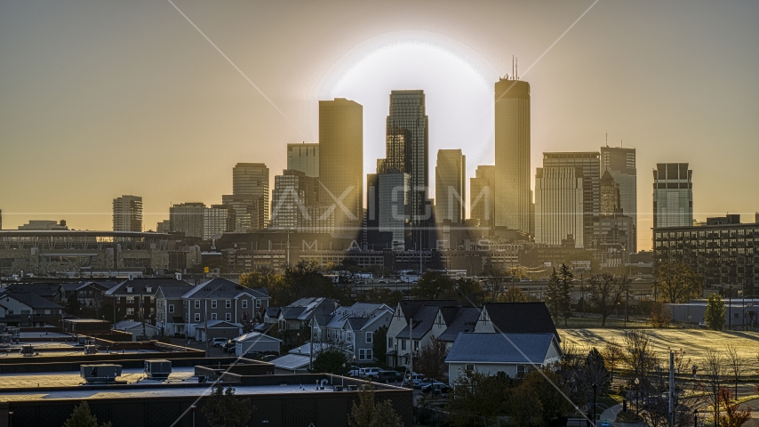 The rising sun peeing out from behind giant skyscrapers in the city's skyline in Downtown Minneapolis, Minnesota Aerial Stock Photo DXP001_000268 | Axiom Images