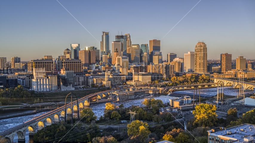 The downtown skyline seen from the Stone Arch Bridge spanning the river at sunrise, Downtown Minneapolis, Minnesota Aerial Stock Photo DXP001_000354 | Axiom Images