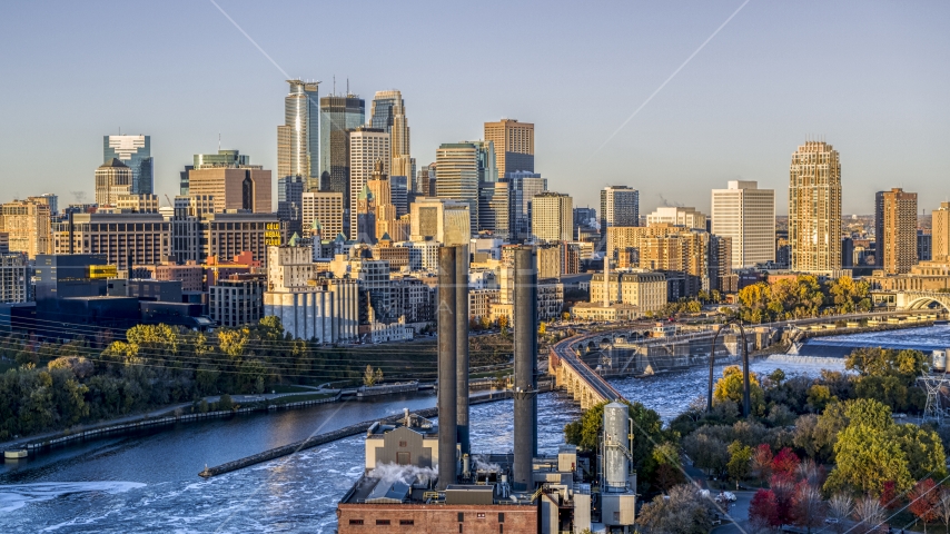 The city's skyline seen from power plant smoke stacks by the Mississippi River at sunrise, Downtown Minneapolis, Minnesota Aerial Stock Photo DXP001_000357 | Axiom Images