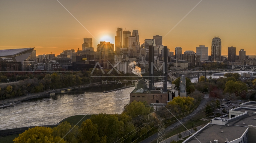 The setting sun behind the skyline across the river, seen from a power plant, Downtown Minneapolis, Minnesota Aerial Stock Photo DXP001_000422 | Axiom Images