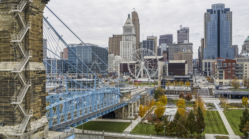 The side of the Roebling Bridge with Ferris wheel and skyscrapers in the background, Downtown Cincinnati, Ohio Aerial Stock Photo DXP001_000470 | Axiom Images