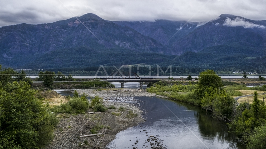 A bridge spanning creek, and mountains across the Columbia River at sunrise, Stevenson, Washington Aerial Stock Photo DXP001_008_0004 | Axiom Images