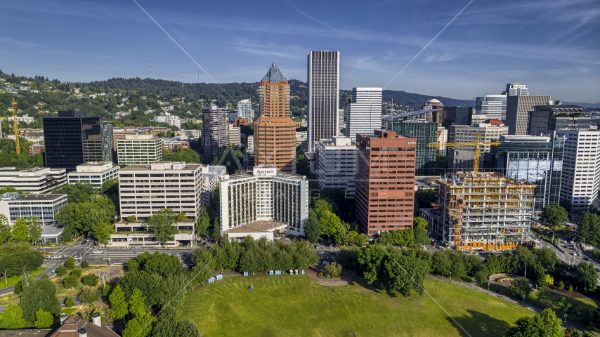 Marriott hotel flanked by taller office buildings and towering skyscrapers in Downtown Portland, Oregon Aerial Stock Photo DXP001_011_0013 | Axiom Images