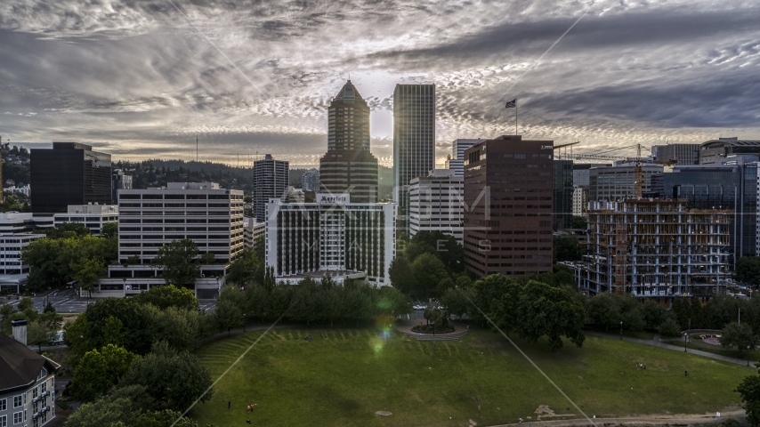 Hotel, office buildings, and setting sun between tall skyscrapers in Downtown Portland, Oregon Aerial Stock Photo DXP001_014_0001 | Axiom Images