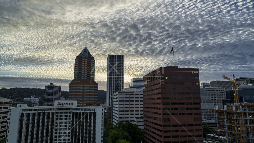 Tall skyscrapers behind hotel and office building at sunset in Downtown Portland, Oregon Aerial Stock Photo DXP001_014_0006 | Axiom Images