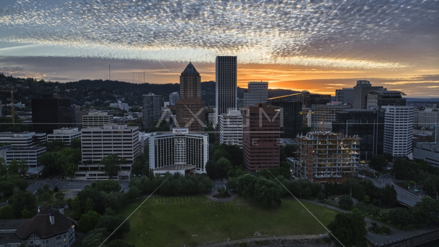 Skyscrapers behind hotel and office building at sunset in Downtown Portland, Oregon Aerial Stock Photo DXP001_014_0007 | Axiom Images