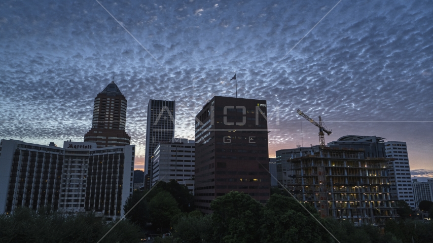 Hotel and office building with skyscrapers in the background at sunset in Downtown Portland, Oregon Aerial Stock Photo DXP001_014_0010 | Axiom Images