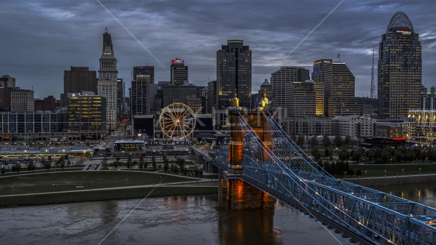 A view of the city skyline and Ferris wheel at sunset, seen from bridge and Ohio River, Downtown Cincinnati, Ohio Aerial Stock Photo DXP001_097_0016 | Axiom Images