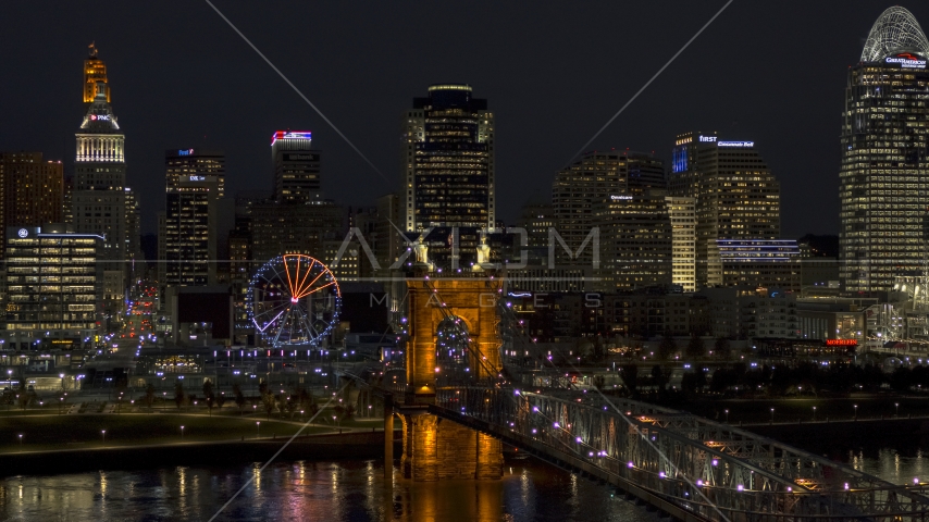 The Ferris wheel by Roebling Bridge at night, with city skyline in background, Downtown Cincinnati, Ohio Aerial Stock Photo DXP001_098_0023 | Axiom Images