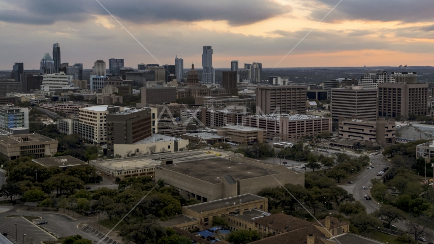 The capitol's dome and office buildings at sunset, skyscrapers in background in Downtown Austin, Texas Aerial Stock Photo DXP002_105_0008 | Axiom Images