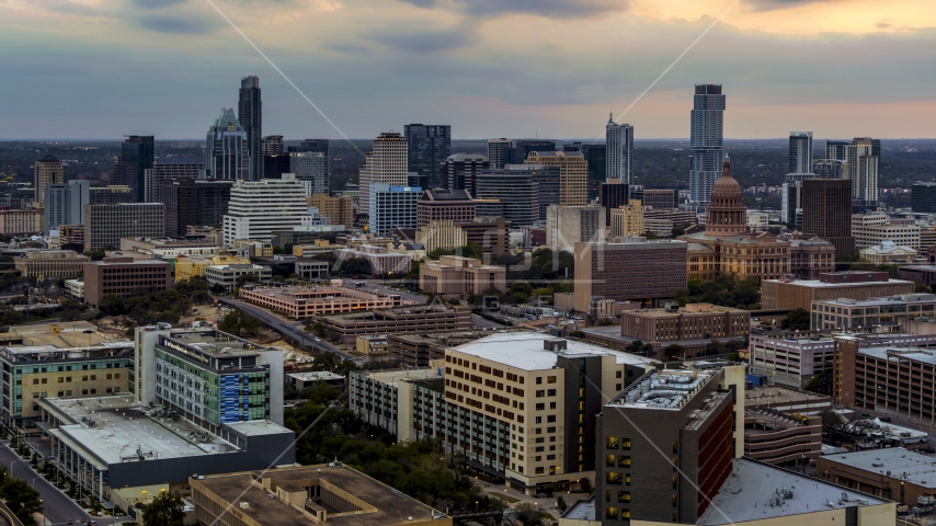 A hospital, with skyscrapers and capitol dome in distance at sunset in Downtown Austin, Texas Aerial Stock Photo DXP002_105_0011 | Axiom Images