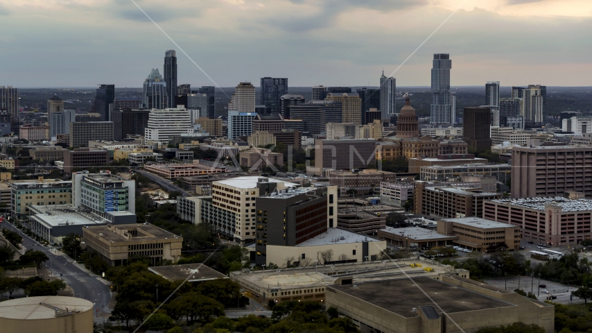 Hospital complex, office buildings and capitol dome at sunset, skyscrapers in distance in Downtown Austin, Texas Aerial Stock Photo DXP002_105_0012 | Axiom Images