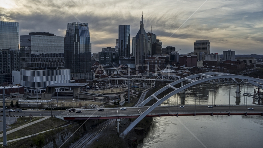 Bridge on Cumberland River at sunset, skyline behind it, Downtown Nashville, Tennessee Aerial Stock Photo DXP002_119_0014 | Axiom Images