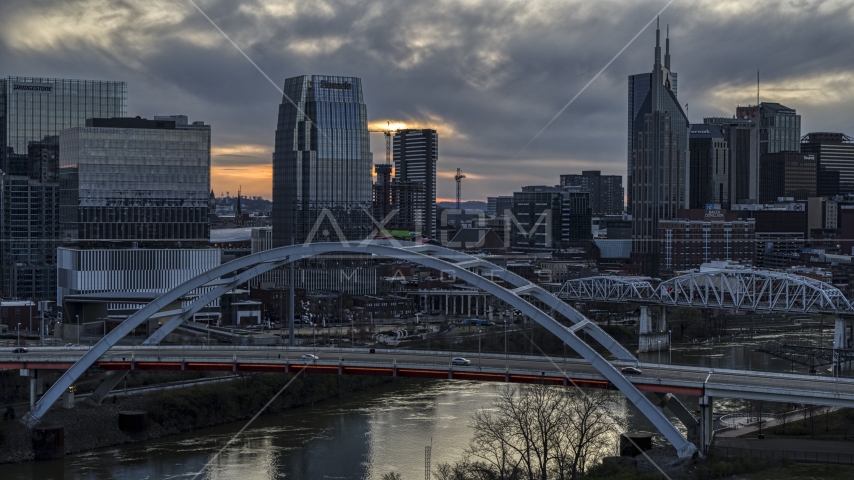 A tall skyscraper seen from a bridge on the river at sunset, Downtown Nashville, Tennessee Aerial Stock Photo DXP002_120_0009 | Axiom Images