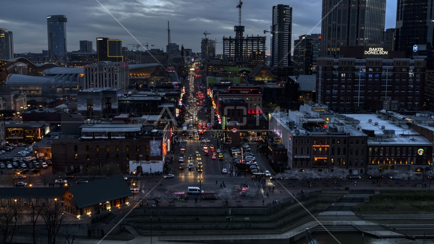 Buildings, cars and pedestrians around Broadway at twilight, Downtown Nashville, Tennessee Aerial Stock Photo DXP002_120_0012 | Axiom Images