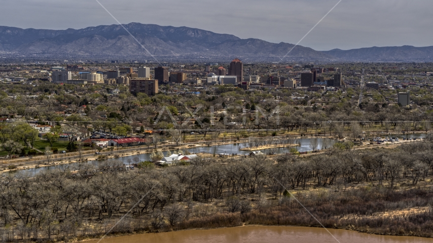 High-rise office buildings seen while flying by park and Rio Grande, Downtown Albuquerque, New Mexico Aerial Stock Photo DXP002_124_0008 | Axiom Images