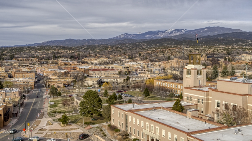 Downtown seen from tower and flags on Bataan Memorial Building, Santa Fe, New Mexico Aerial Stock Photo DXP002_131_0007 | Axiom Images