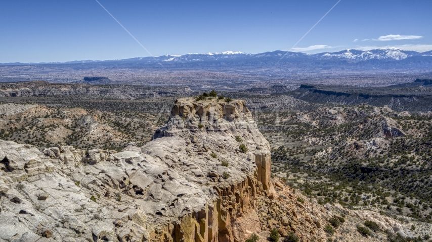 The end of a desert mesa with a view of distance mountains in New Mexico Aerial Stock Photo DXP002_133_0010 | Axiom Images