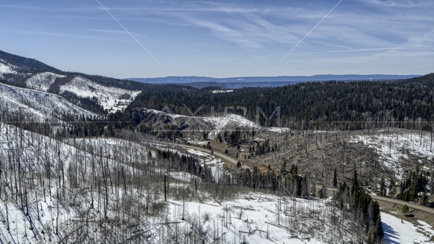 Black cars on a winding road by snowy mountains, New Mexico Aerial Stock Photo DXP002_134_0017 | Axiom Images