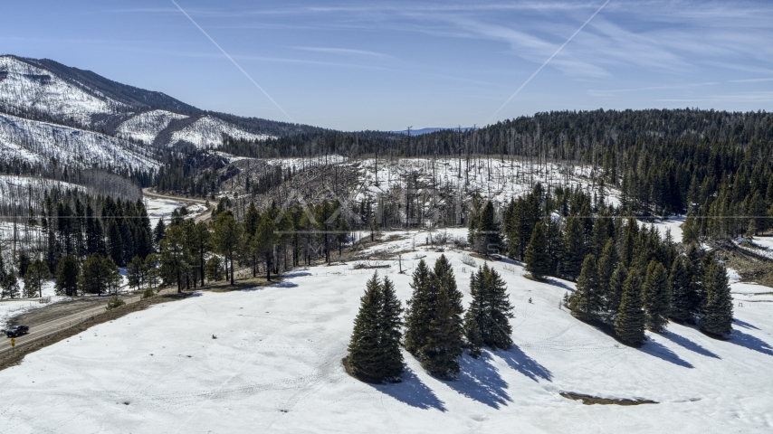 Snowy mountains and a winding road in New Mexico Aerial Stock Photo DXP002_134_0018 | Axiom Images