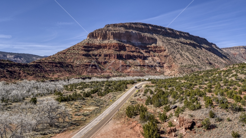 Black car on a desert road near a butte, New Mexico Aerial Stock Photo DXP002_135_0001 | Axiom Images