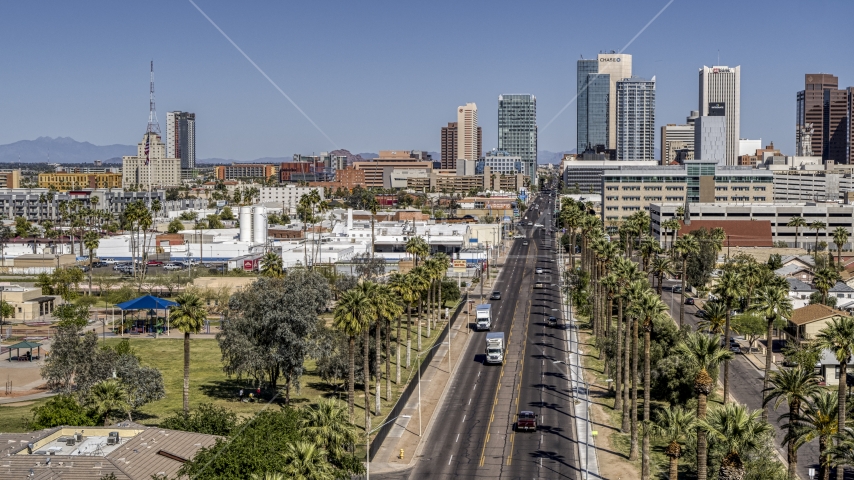 Palm trees at city park and street leading to tall office buildings in Downtown Phoenix, Arizona Aerial Stock Photo DXP002_137_0002 | Axiom Images