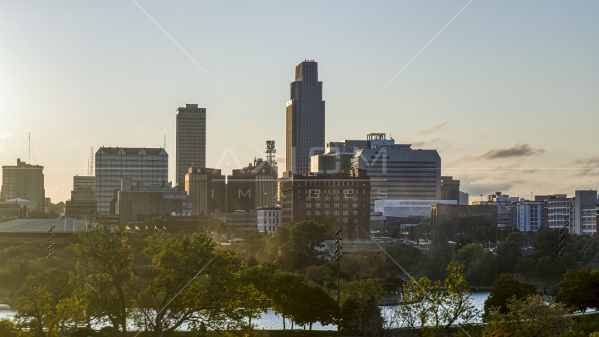 A tall skyscraper seen from a city park at sunset, Downtown Omaha, Nebraska Aerial Stock Photo DXP002_172_0008 | Axiom Images