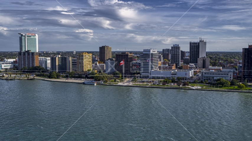 A view of office buildings and Canadian flag by the river in Windsor, Ontario, Canada Aerial Stock Photo DXP002_196_0004 | Axiom Images