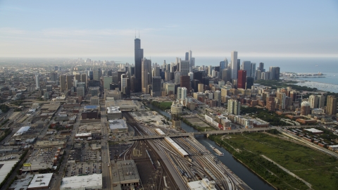 AX0001_076.0000284F - Aerial stock photo of Train yards by the Chicago River near the downtown skyline on a hazy day, Downtown Chicago, Illinois