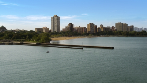 AX0002_002.0000028F - Aerial stock photo of Piers on Lake Michigan near a beach and apartment buildings in Hyde Park, Chicago, Illinois